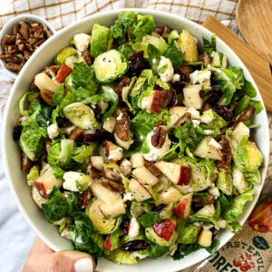 holding a bowl of brussel sprout salad, top view