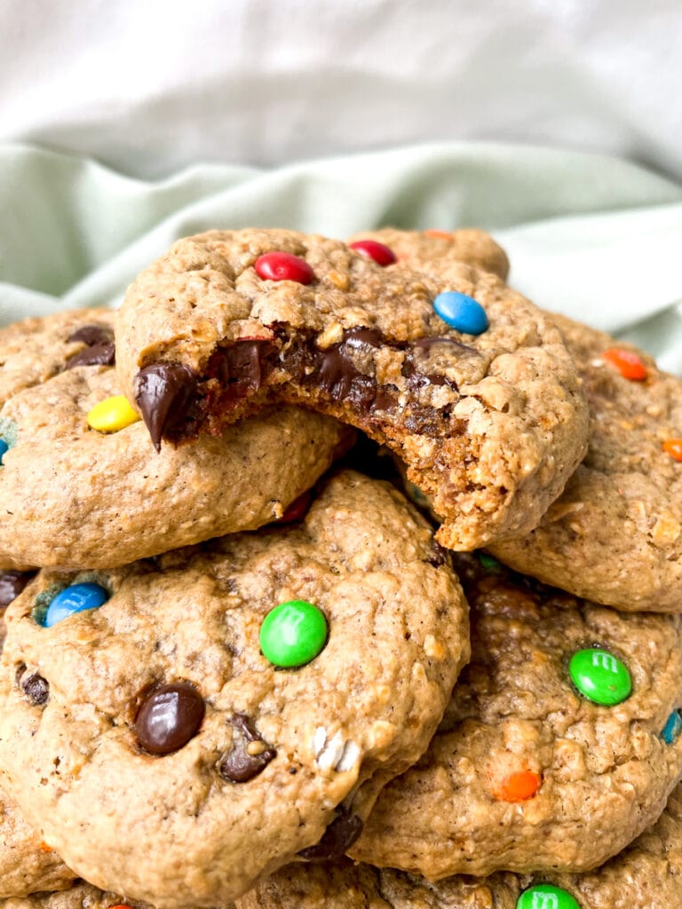 close up of a stack of monster cookies with a white background