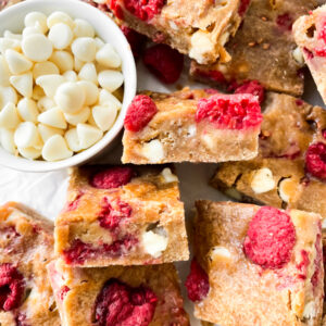 top view of a batch of raspberry blondies next to a bowl of white chocolate chips