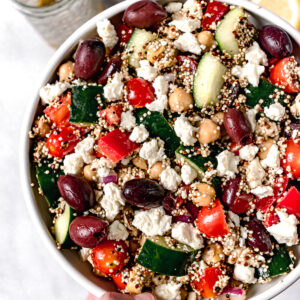 holding a bowl of quinoa salad