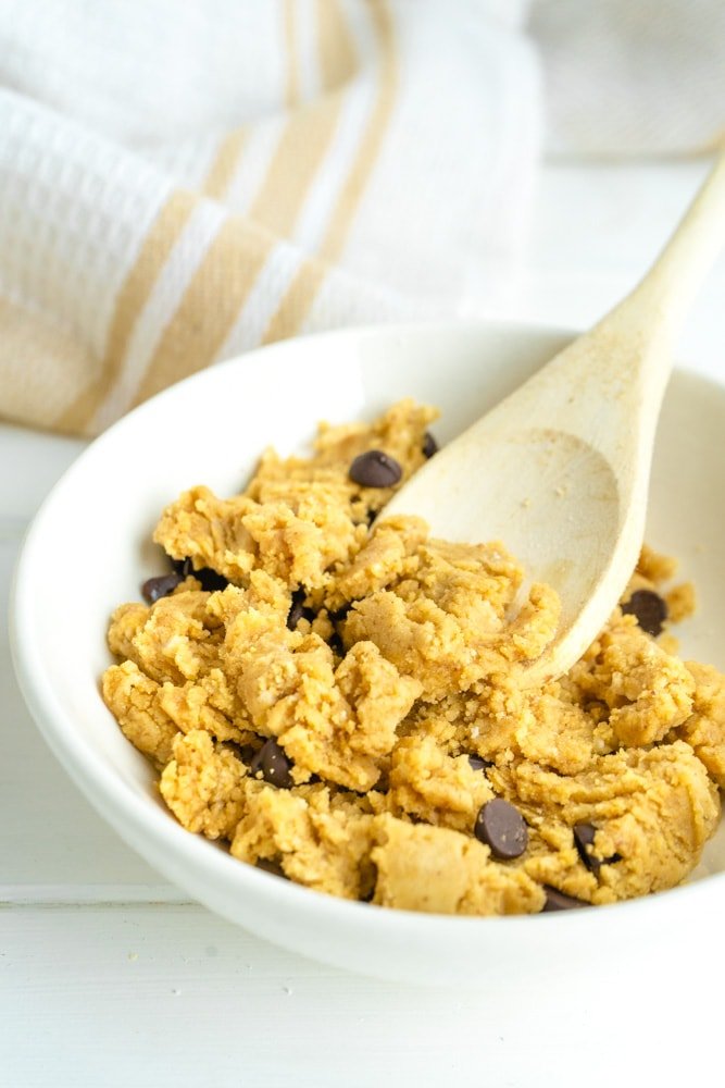 bowl of protein cookie dough with a wooden spoon