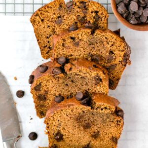 top shot of slices of pumpkin bread next to a bowl of chocolate chips