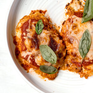 gluten free chicken parm with marinara and basil garnish