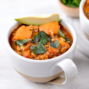close up of whole 30 chili in a white and cream bowl