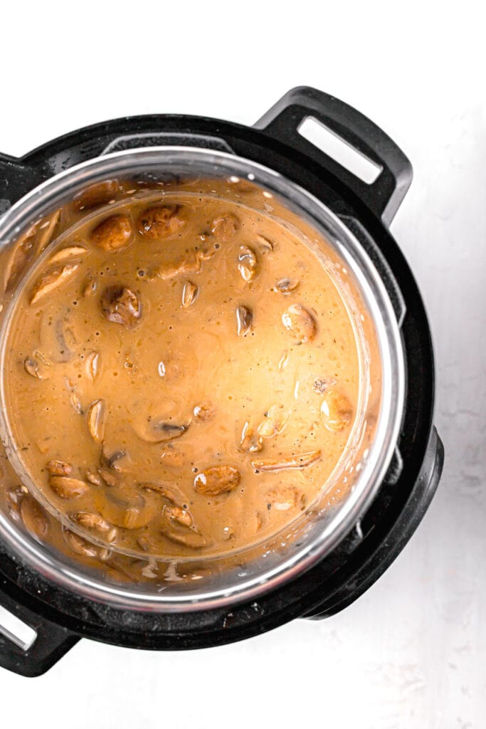 ingredients being added in the slow cooker for mushroom chicken