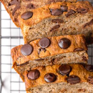 sliced vegan banana bread with chocolate chips on a wire rack