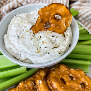 garlic and herb dip in a bowl with pretzels