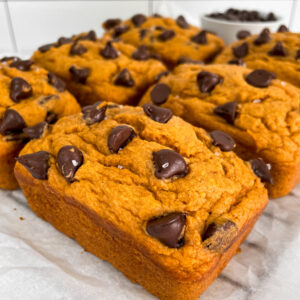 side angle of vegan 5 ingredient pumkin bread mini loaves on a cooling rack with parchment paper