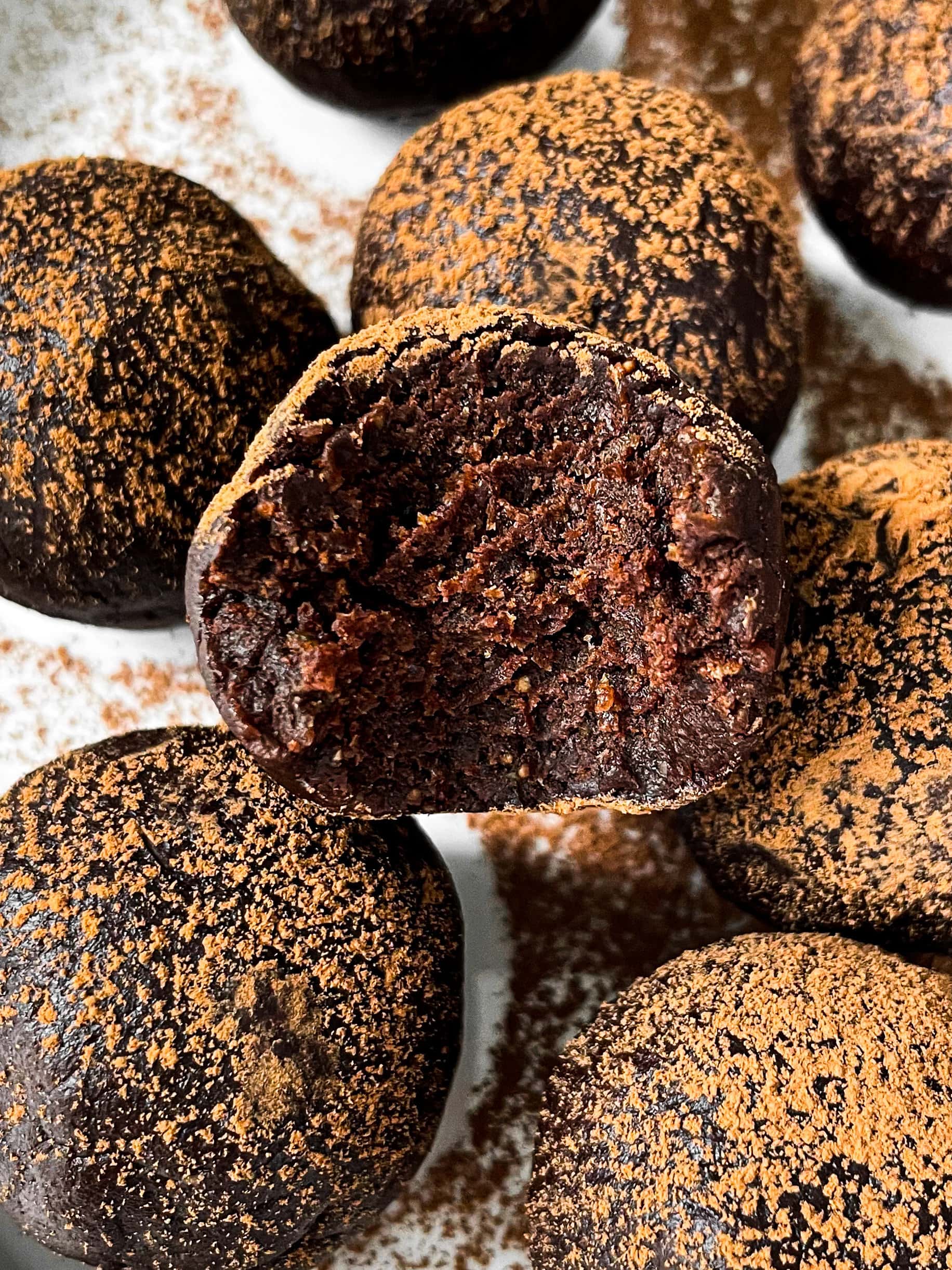 close up of a batch of brownie truffles with a bite taken out of one