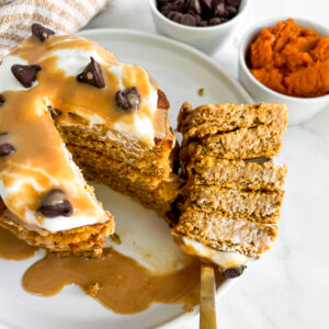 a stack of gluten free pumpkin pancakes with a bite on a fork