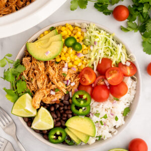 crockpot salsa chicken in a bowl with salad ingredients