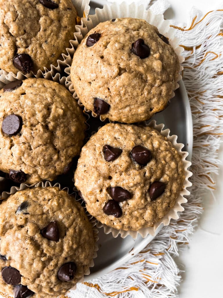 top view of a plate of oatmeal chocolate chip muffins still in the liners