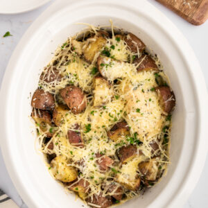 top view of crockpot parmesan garlic chicken in the pot with cheese