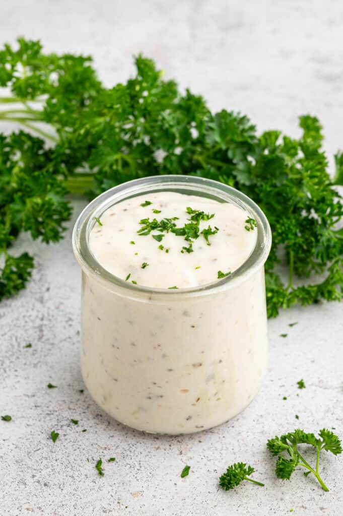 Small glass jar of cottage cheese alfredo sauce topped with parsley.