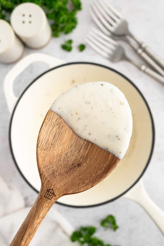 Scooping the blended cottage cheese pasta sauce up on the spoon.