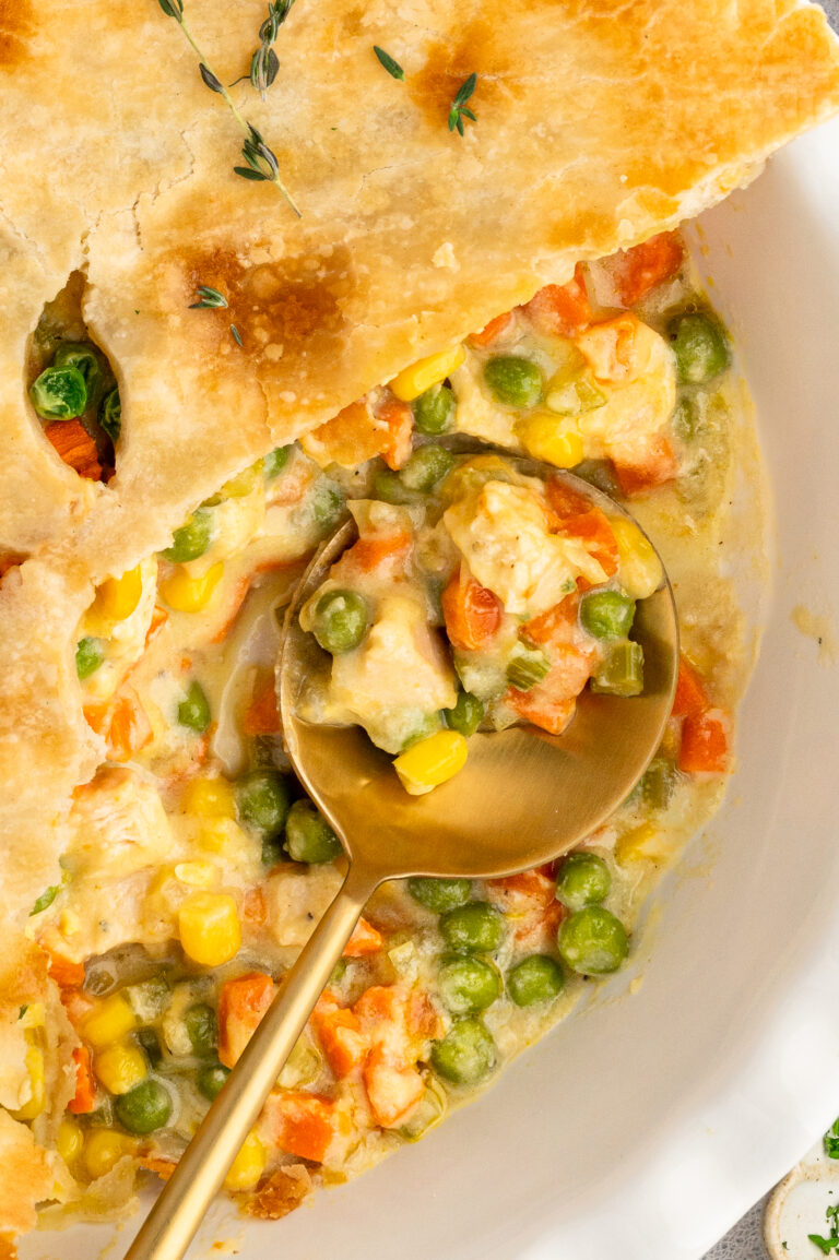 Close up of the creamy filling in the chicken pot pie on a spoon.
